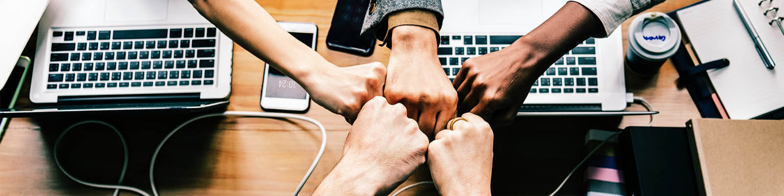 hands hi five and computers in the background